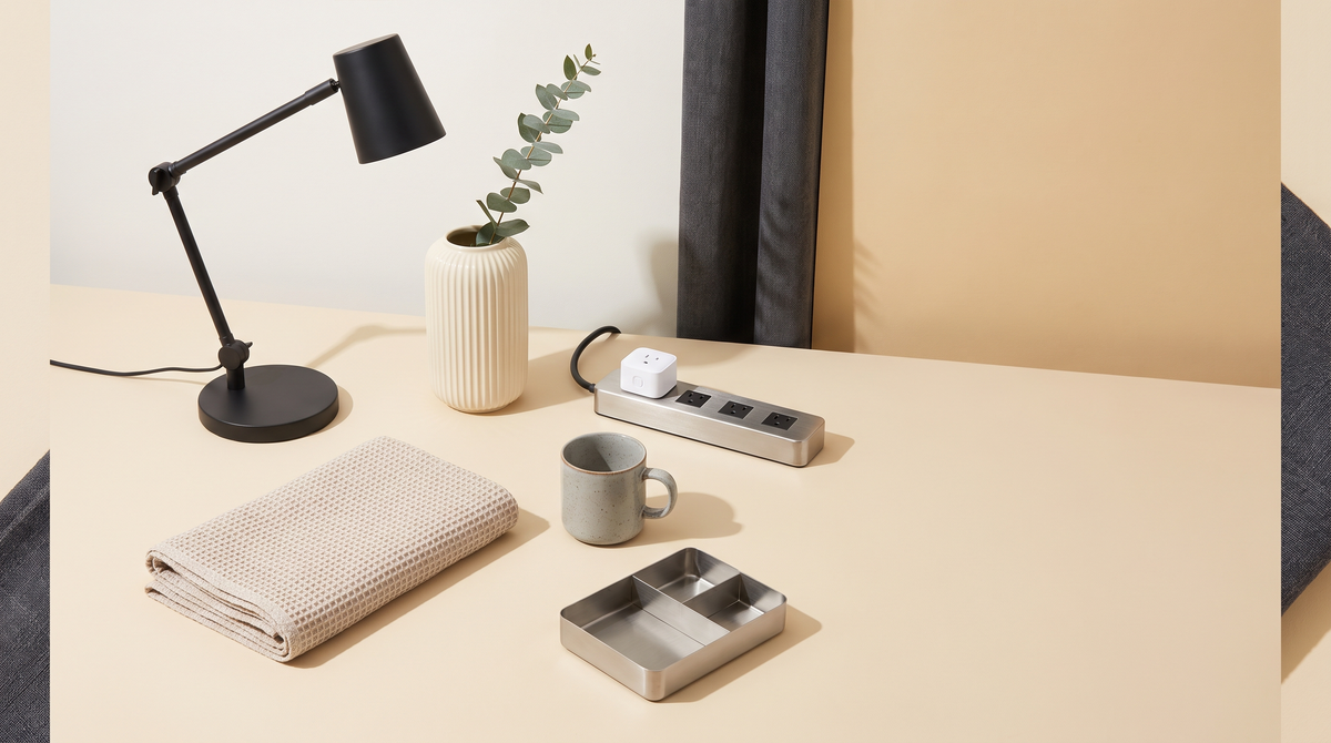 Newly arrived home goods laid out including a desk lamp, ceramic vase, smart plug and towel