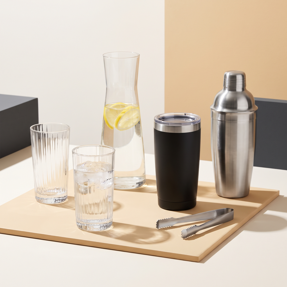 Drinkware group with ribbed highball glasses, a carafe, insulated tumbler and cocktail shaker