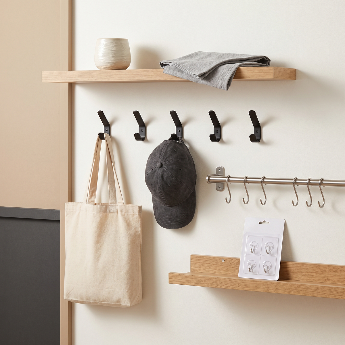 Oak floating shelves with a row of matte black wall hooks and a rail with S-hooks