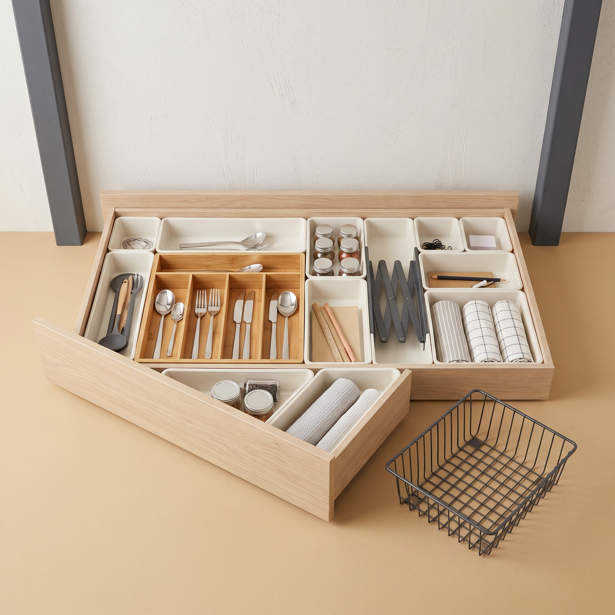 Open drawer fitted with organiser trays, a bamboo cutlery insert and adjustable divider