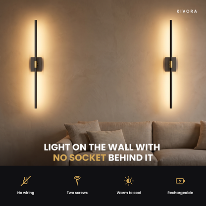 A pair of Ansel sconces lighting a living room wall above a sofa — no wiring, two screws, warm to cool, rechargeable